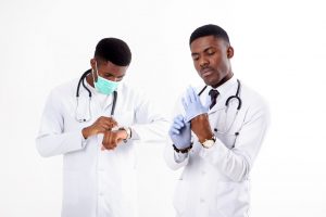 Two young african doctors on an isolated white background with a phonendoscope. One of them with mask.